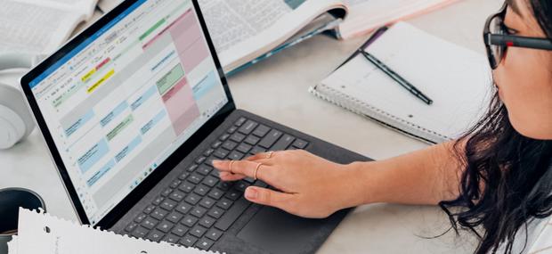 Pige sidder med opgaveskrivning ved en computer