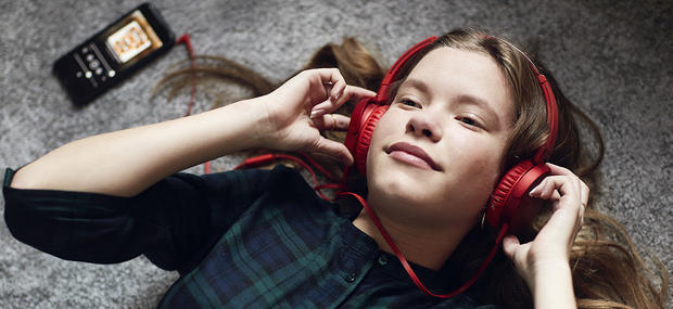 Foto af pige med hovedtelefoner, der lytter til en lydbog fra eReolen Go!