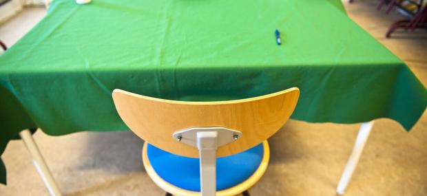 Eksamensbord med det grønne klæde og tom stol