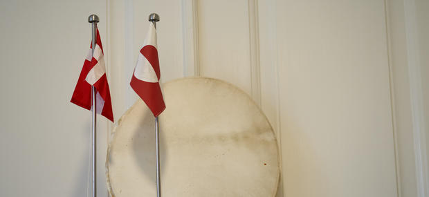 Det grønlandske og danske flag, samt en grønlandsk tromme