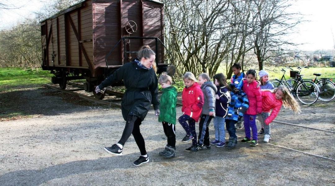 Underviser går på række med små elever